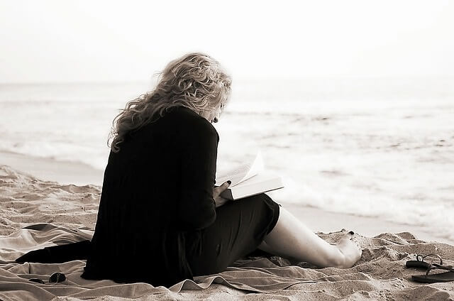 mujer leyendo libro playa deprimida